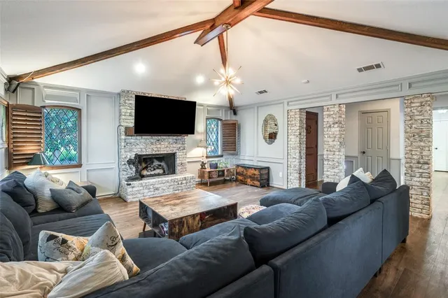 a living room with furniture a flat screen tv and a fireplace
