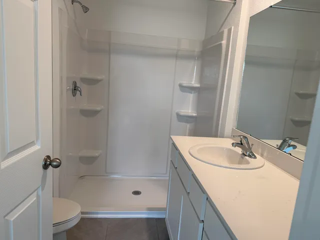 a bathroom with a sink a toilet and shower