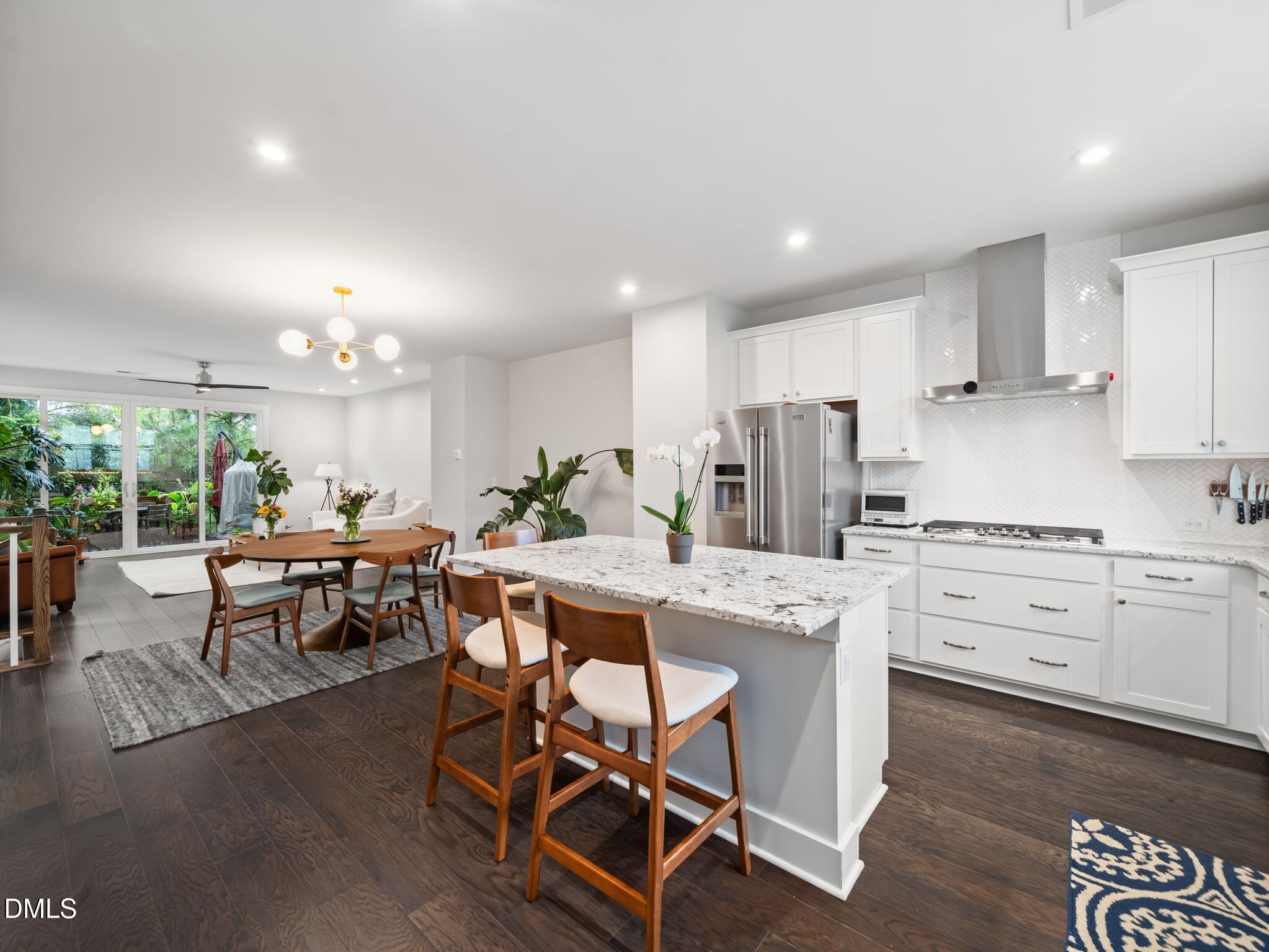 916 Waterside View Drive Raleigh, NC 27606 - Photo 8 of 22 a kitchen with stainless steel appliances kitchen island granite countertop a stove a sink a dining table and chairs with wooden floor