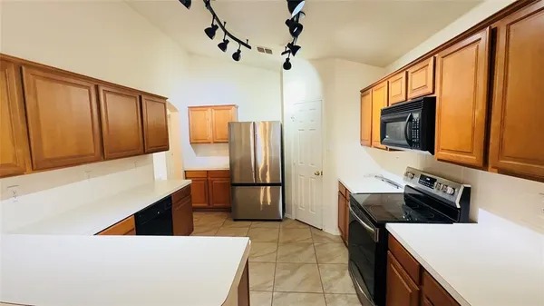 a kitchen with stainless steel appliances a stove microwave and refrigerator