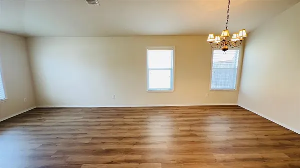 a view of a room with wooden floor and chandelier
