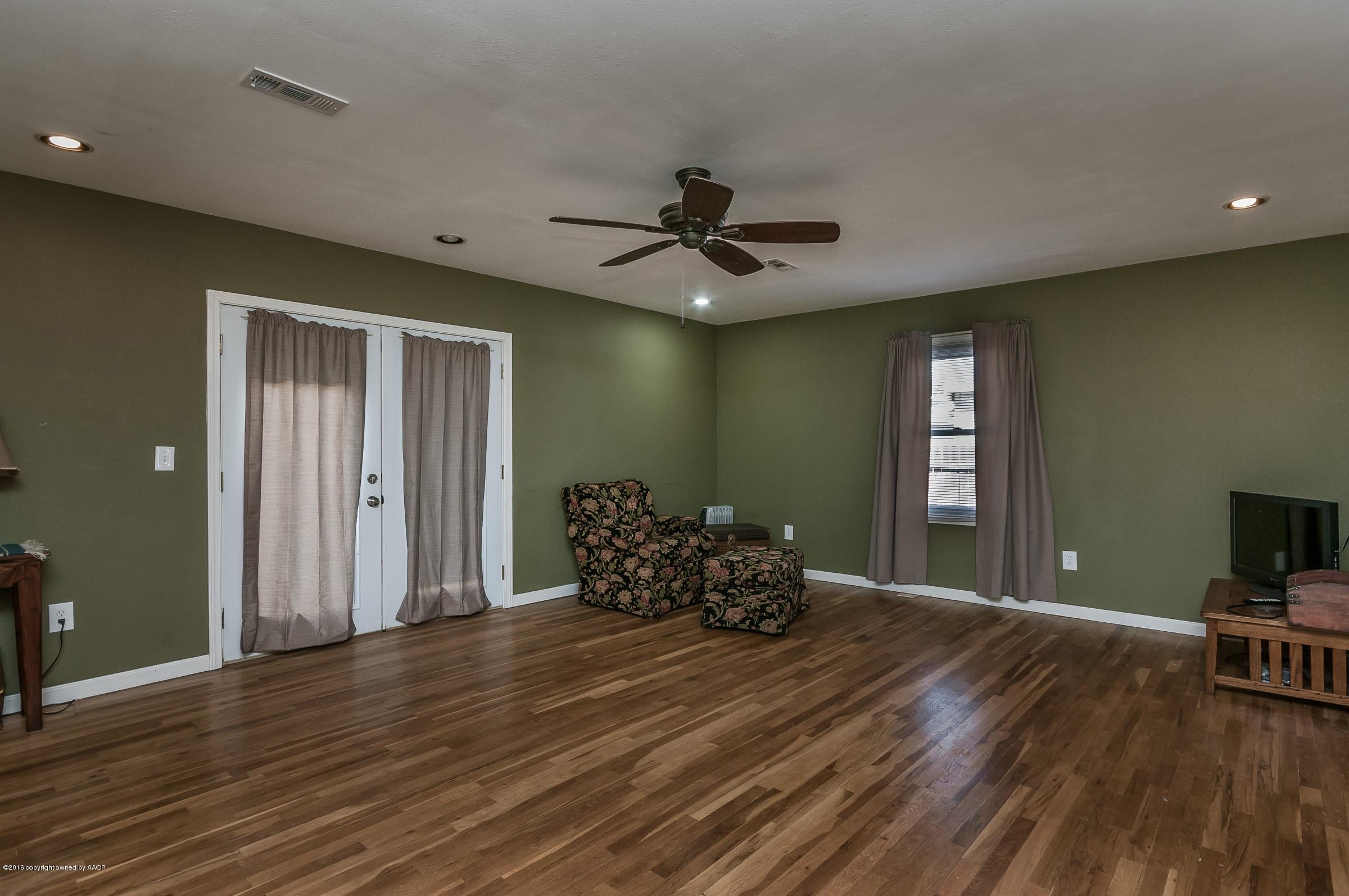 4402 Parker Street Amarillo, TX 79110 - Photo 11 of 21 a furnished livingroom with a window and wooden floor