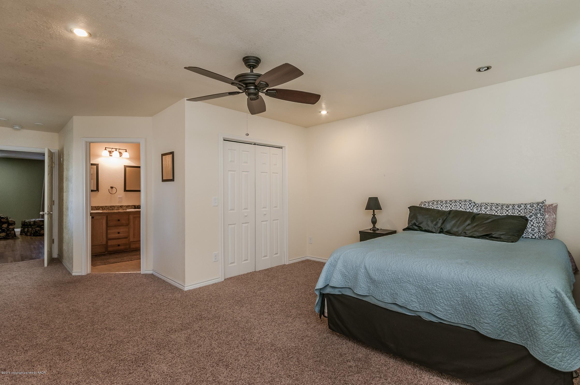 4402 Parker Street Amarillo, TX 79110 - Photo 14 of 21 a bedroom with a bed and a chandelier