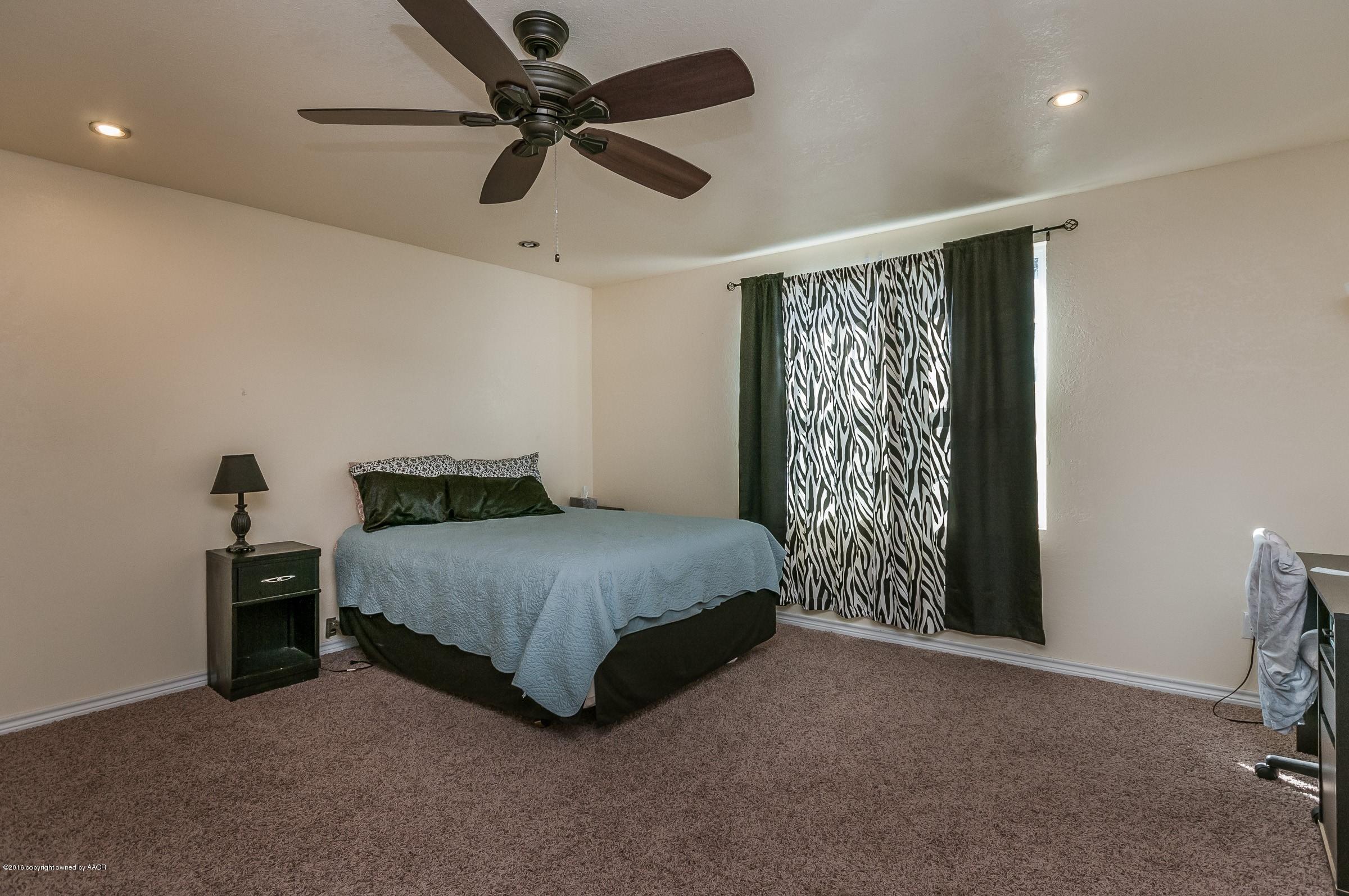 4402 Parker Street Amarillo, TX 79110 - Photo 16 of 21 a spacious bedroom with a bed and a chandelier