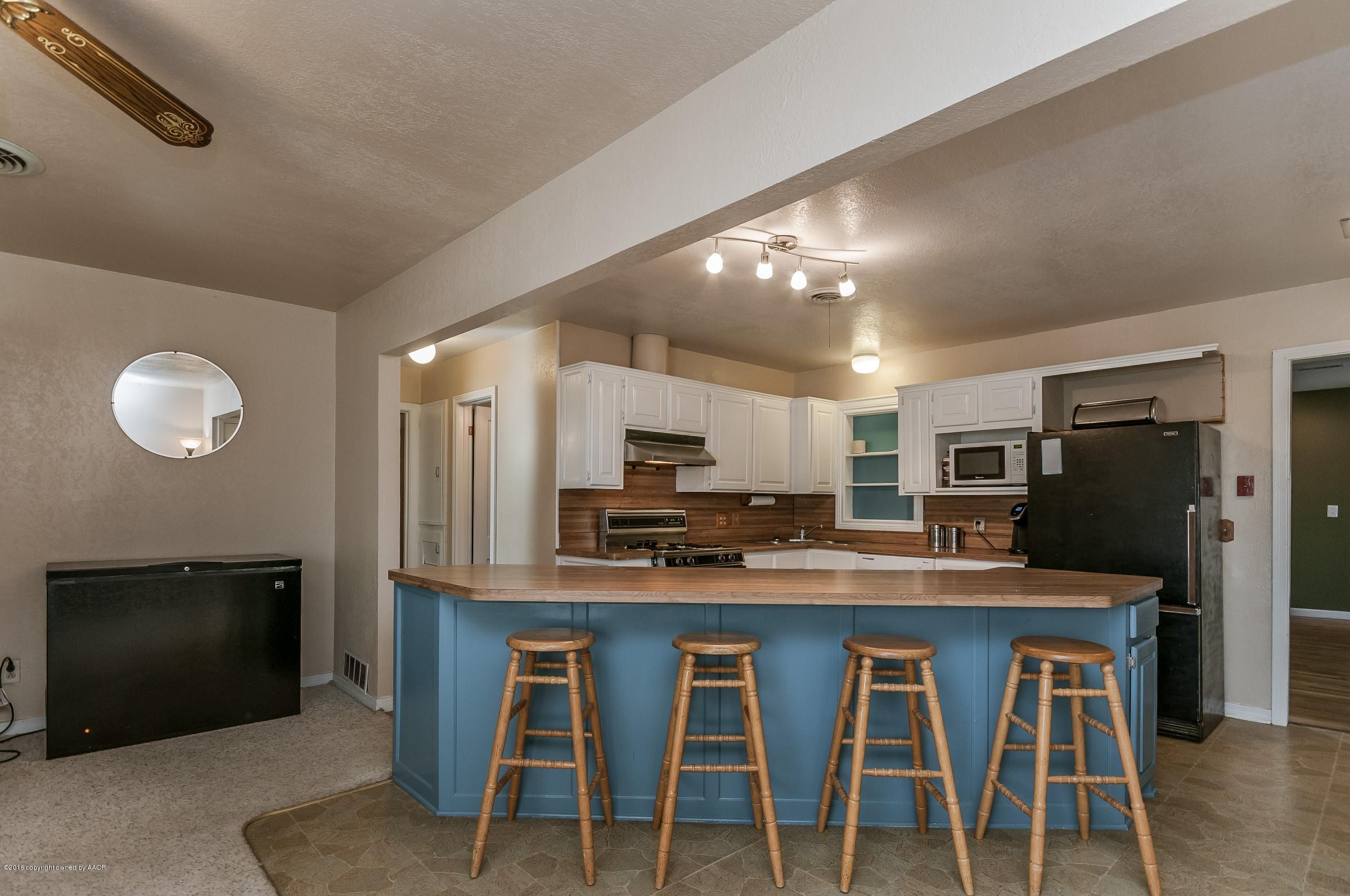 4402 Parker Street Amarillo, TX 79110 - Photo 5 of 21 a kitchen with kitchen island cabinets and stainless steel appliances