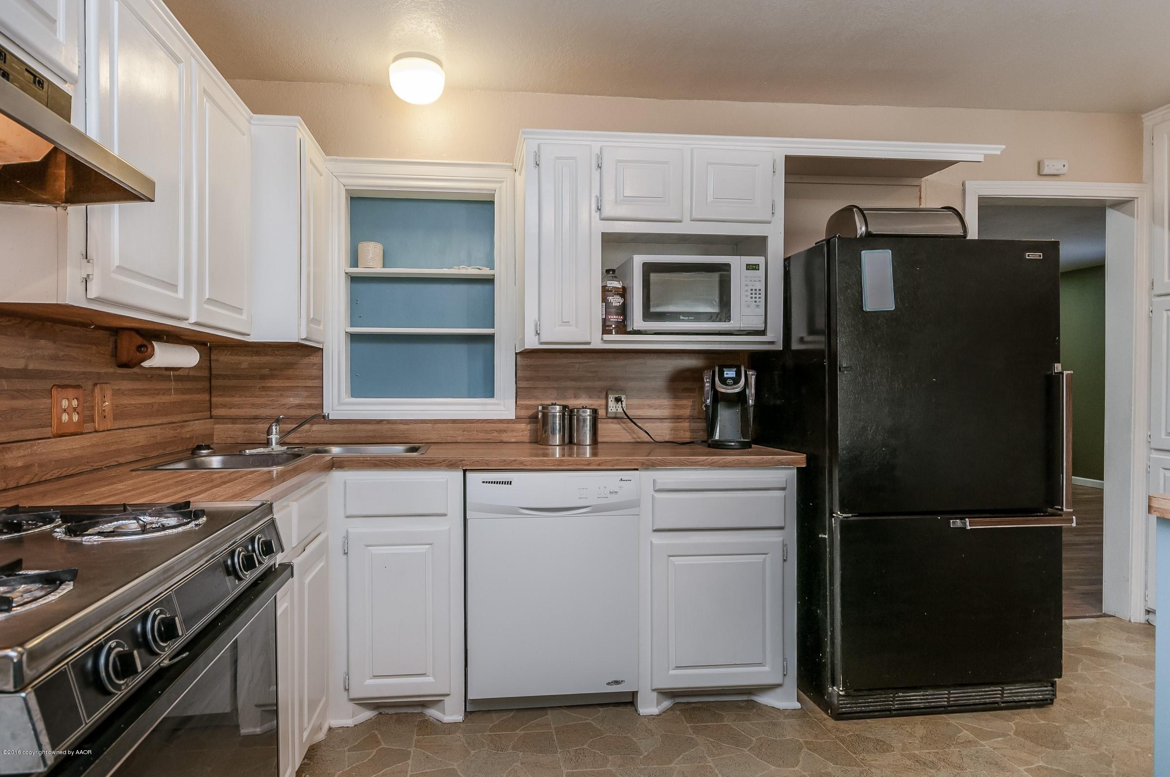 4402 Parker Street Amarillo, TX 79110 - Photo 7 of 21 a kitchen with a refrigerator stove and sink
