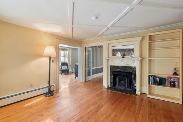 a view of a livingroom with wooden floor a fireplace and window