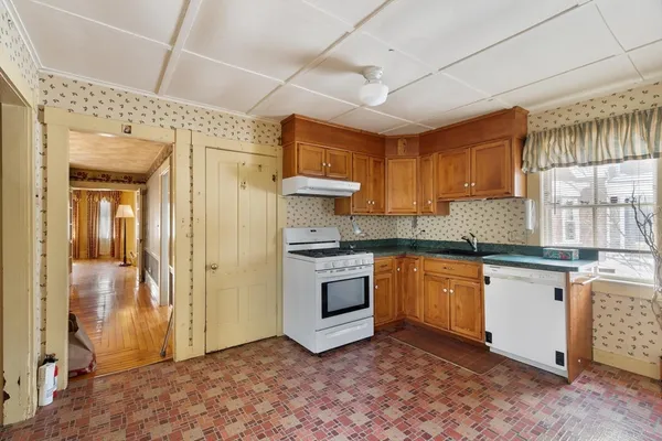 a kitchen with stainless steel appliances granite countertop a sink a stove a refrigerator with grey cabinets