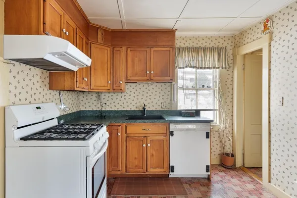 a kitchen with a stove a sink and cabinets