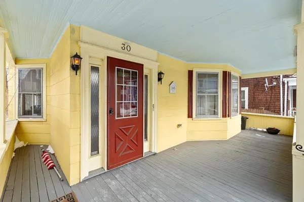 a view of a hallway with wooden floor and windows