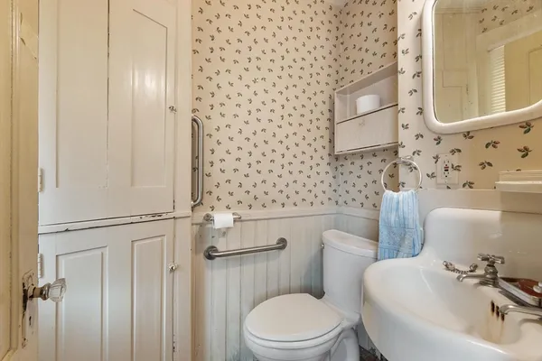 a white toilet sitting next to a bathroom sink