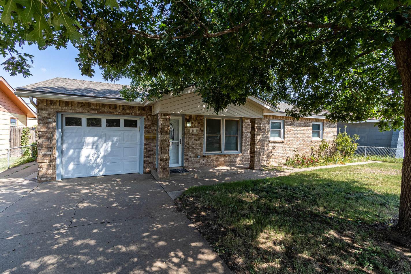 4413 Southeast 28th Avenue Amarillo, TX 79103 - Photo 1 of 13 a front view of a house with yard and green space