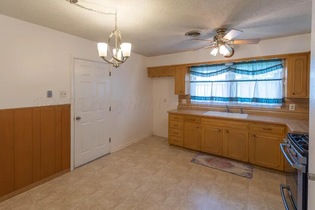 a kitchen that has a lot of cabinets and wooden floor