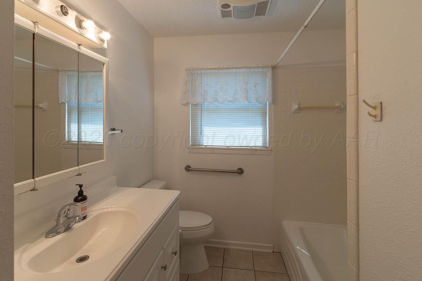 4413 Southeast 28th Avenue Amarillo, TX 79103 - Photo 7 of 13 a bathroom with a sink toilet and shower