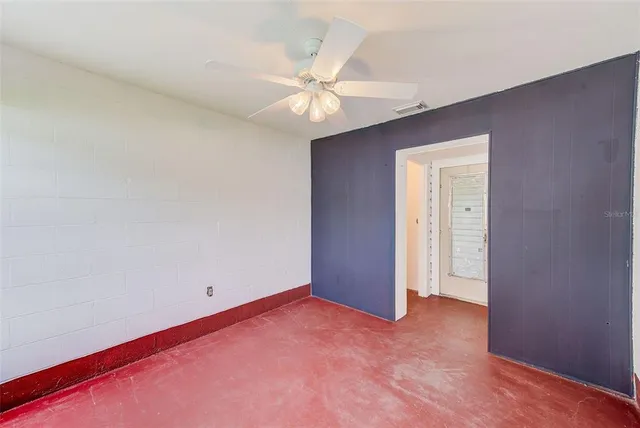 an empty room with a ceiling fan and closet area