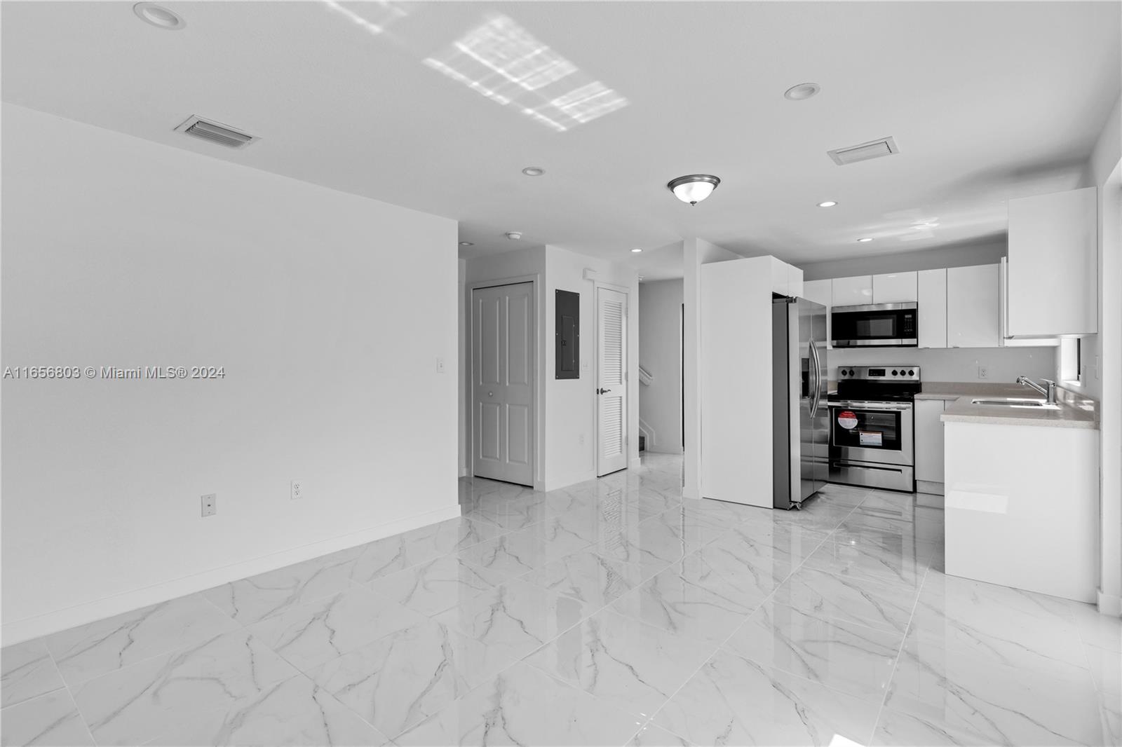 1801 Northwest 112th Street, Unit 1 Miami, FL 33167 - Photo 4 of 22 a view of a kitchen with refrigerator and chairs