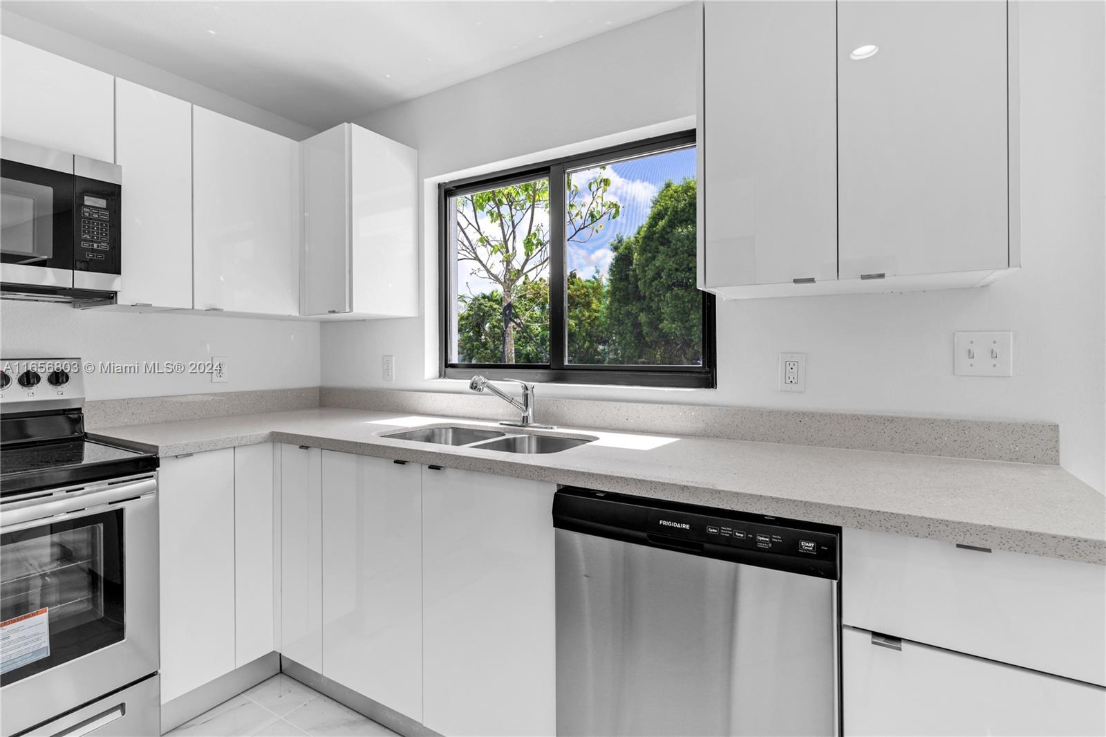 1801 Northwest 112th Street, Unit 1 Miami, FL 33167 - Photo 5 of 22 a kitchen with stainless steel appliances granite countertop a sink a stove and a microwave