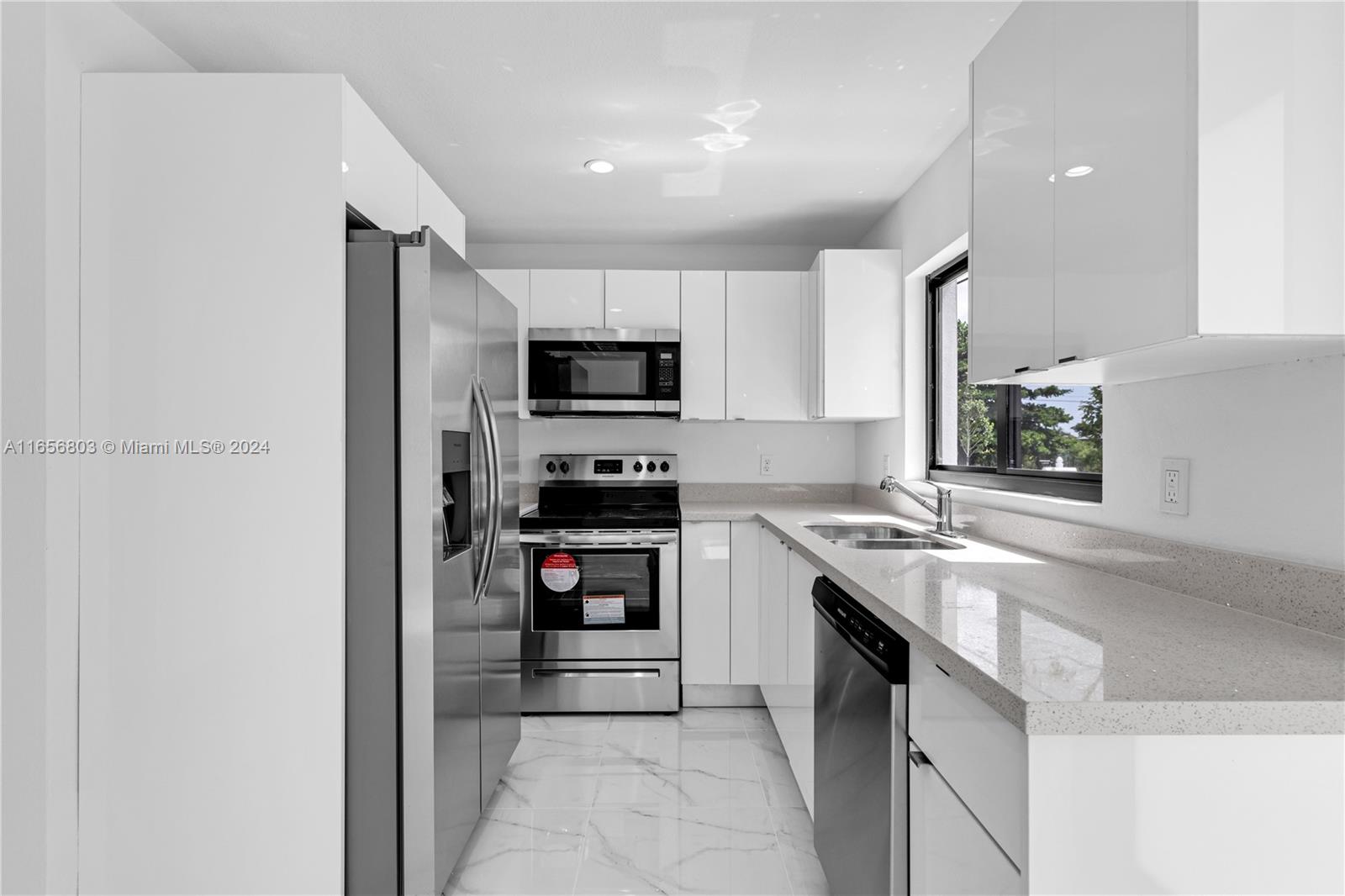 1801 Northwest 112th Street, Unit 1 Miami, FL 33167 - Photo 6 of 22 a kitchen with kitchen island a sink stainless steel appliances and cabinets