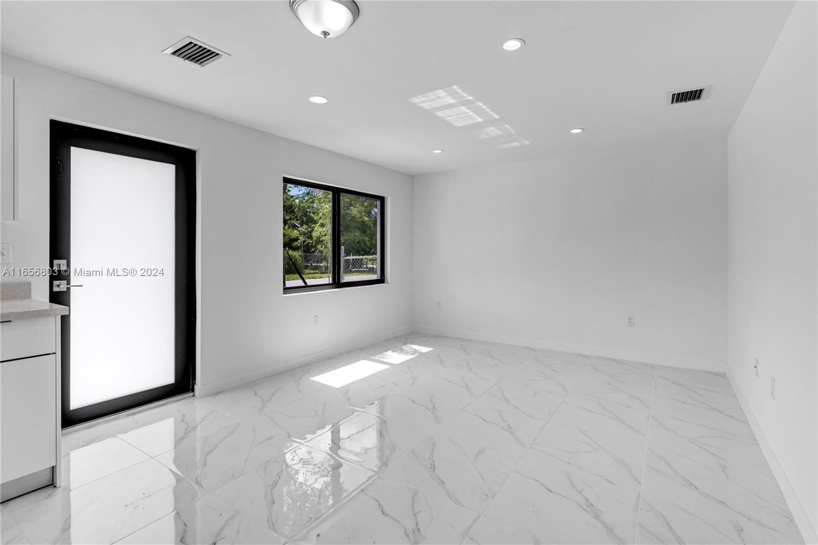 1801 Northwest 112th Street, Unit 1 Miami, FL 33167 - Photo 8 of 22 a view of an empty room with a window