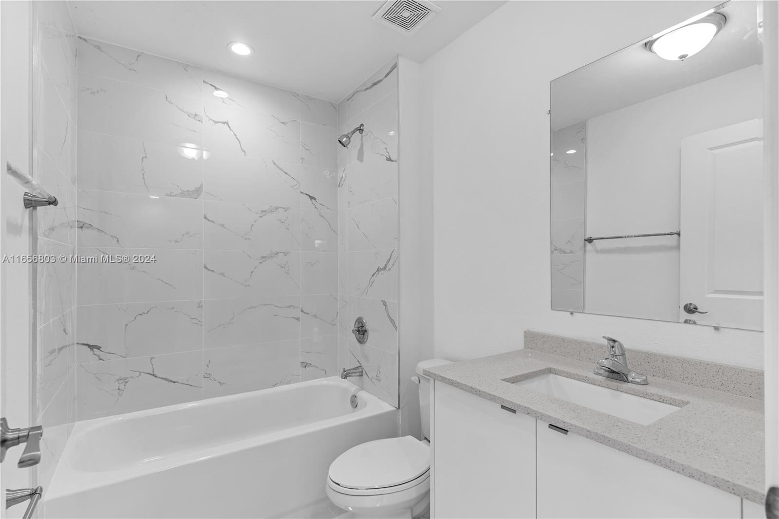 1801 Northwest 112th Street, Unit 1 Miami, FL 33167 - Photo 9 of 22 a bathroom with a granite countertop sink toilet mirror and bathtub