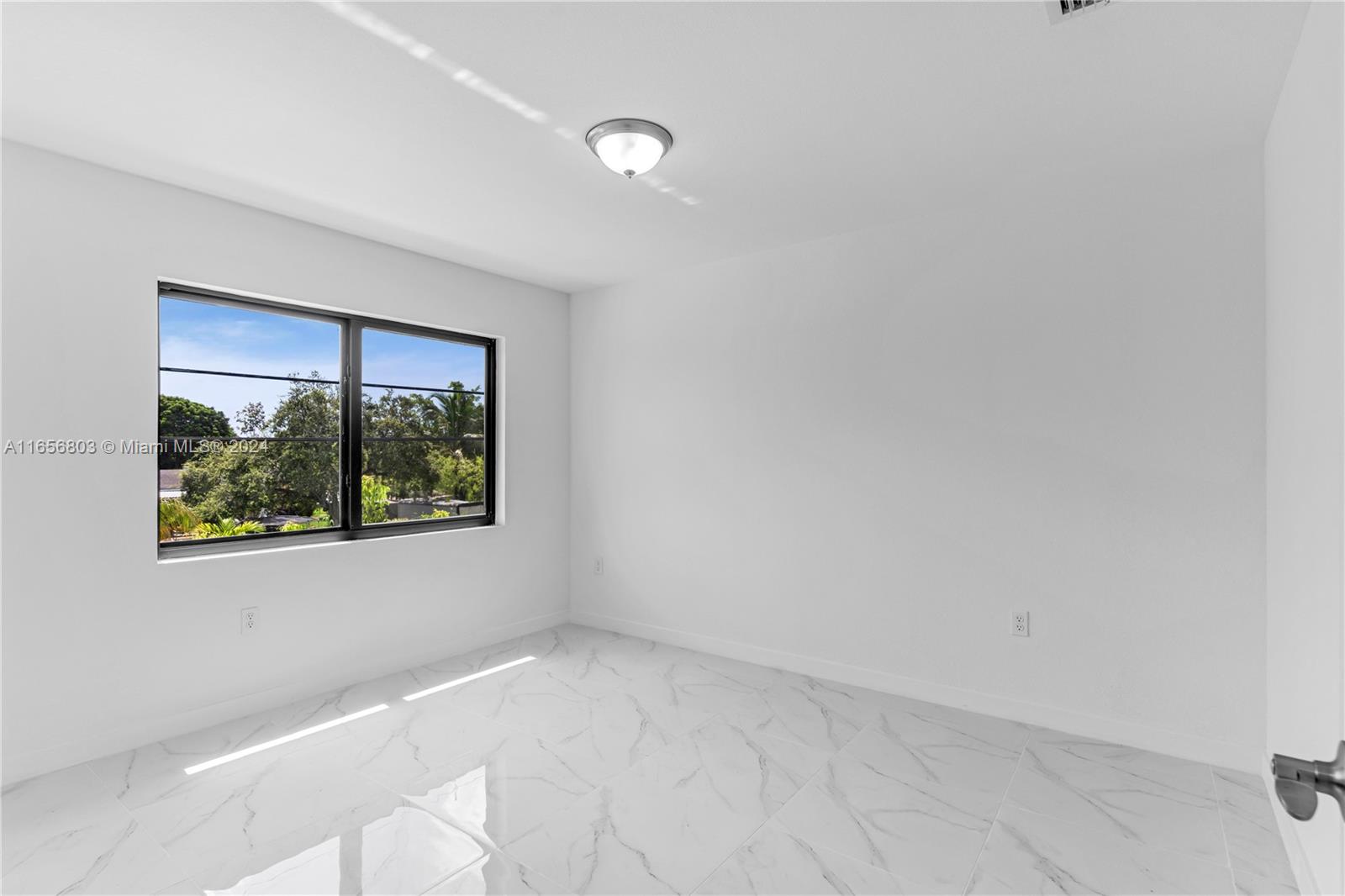 1801 Northwest 112th Street, Unit 1 Miami, FL 33167 - Photo 10 of 22 a view of an empty room with a window