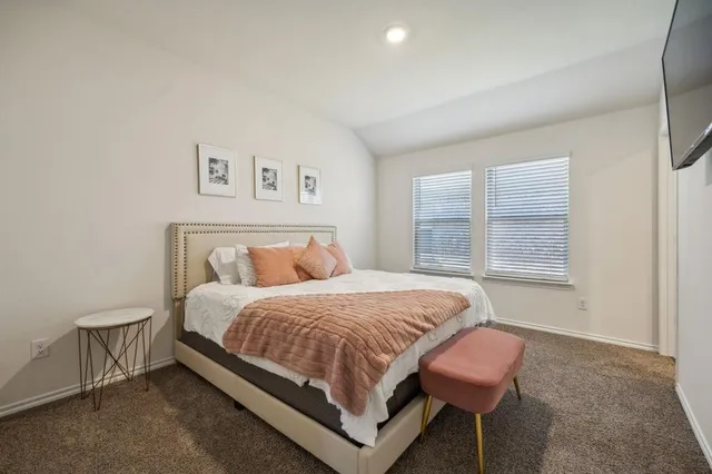 a bedroom with a bed lamp and a window