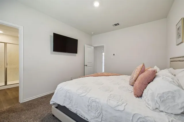 a bedroom with a bed and a flat screen tv