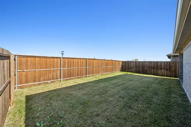 a view of backyard with wooden fence