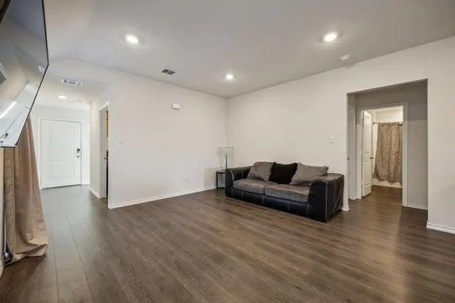 a living room with furniture and a wooden floor
