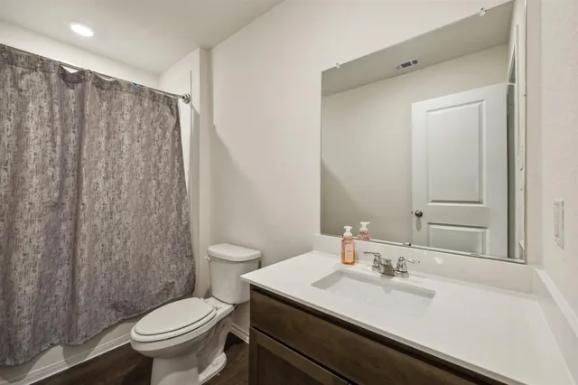 a bathroom with a granite countertop sink toilet and a mirror