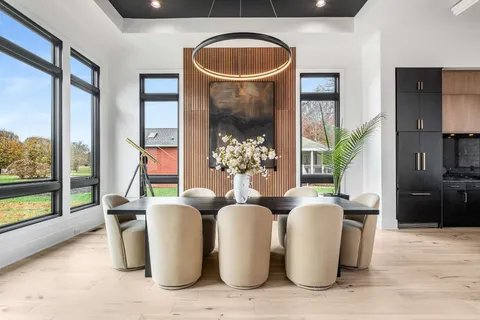 a kitchen with stainless steel appliances kitchen island granite countertop a table chairs sink and cabinets