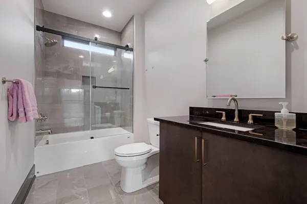 a bathroom with a sink a toilet and shower