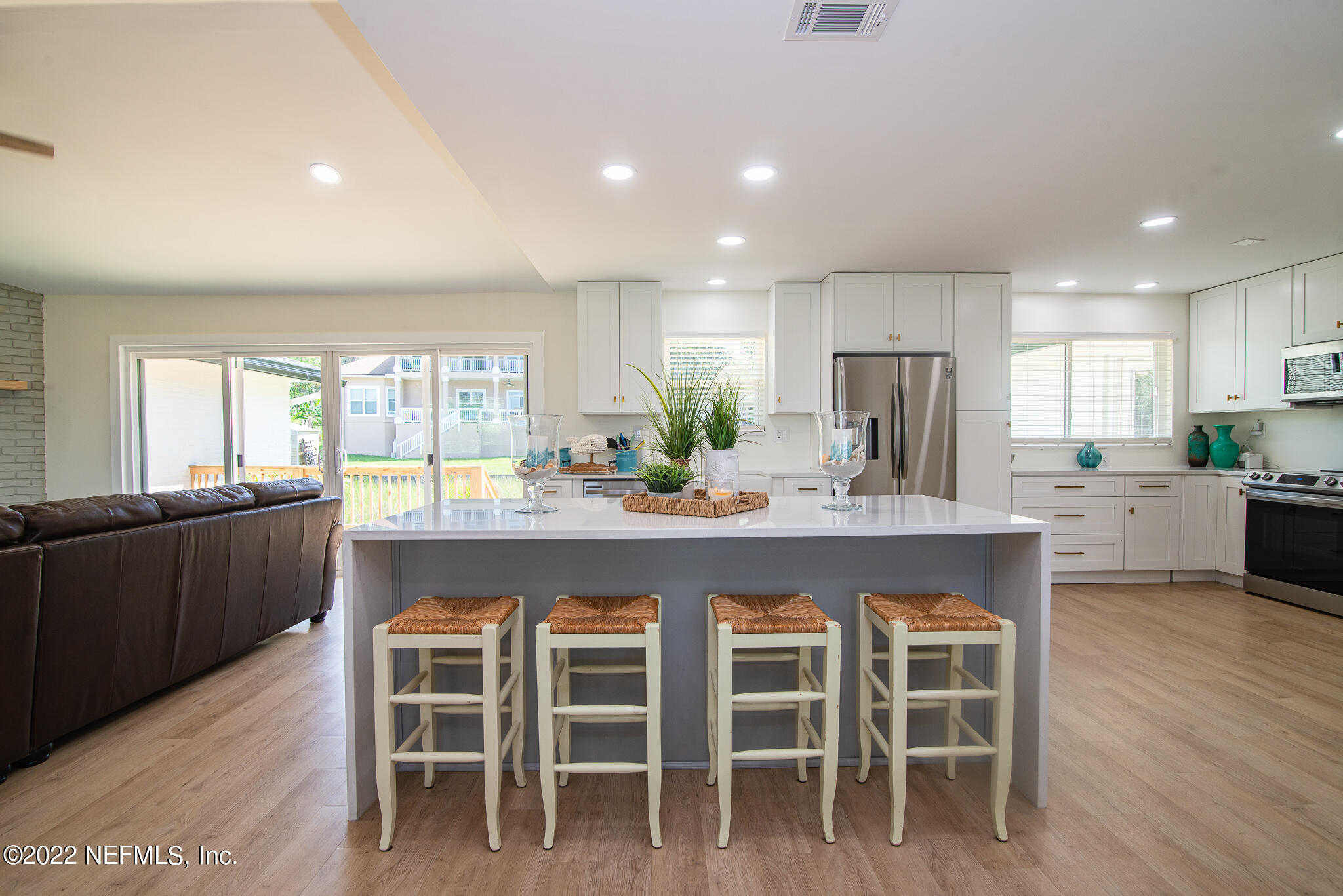 4268 Heath Road Jacksonville, FL 32277 - Photo 11 of 43 a large kitchen with granite countertop a dining table chairs and wooden floor