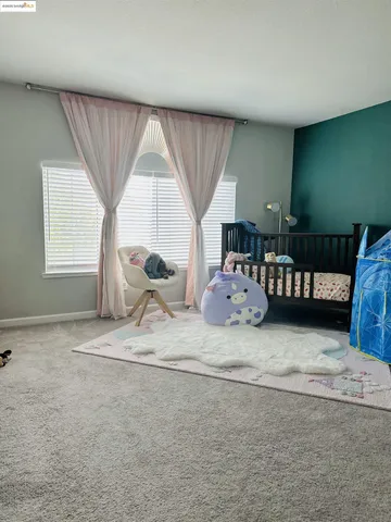 a bedroom with furniture and a large window
