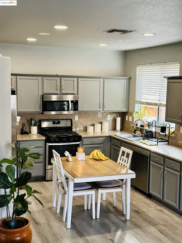 a kitchen with a table chairs microwave and cabinets