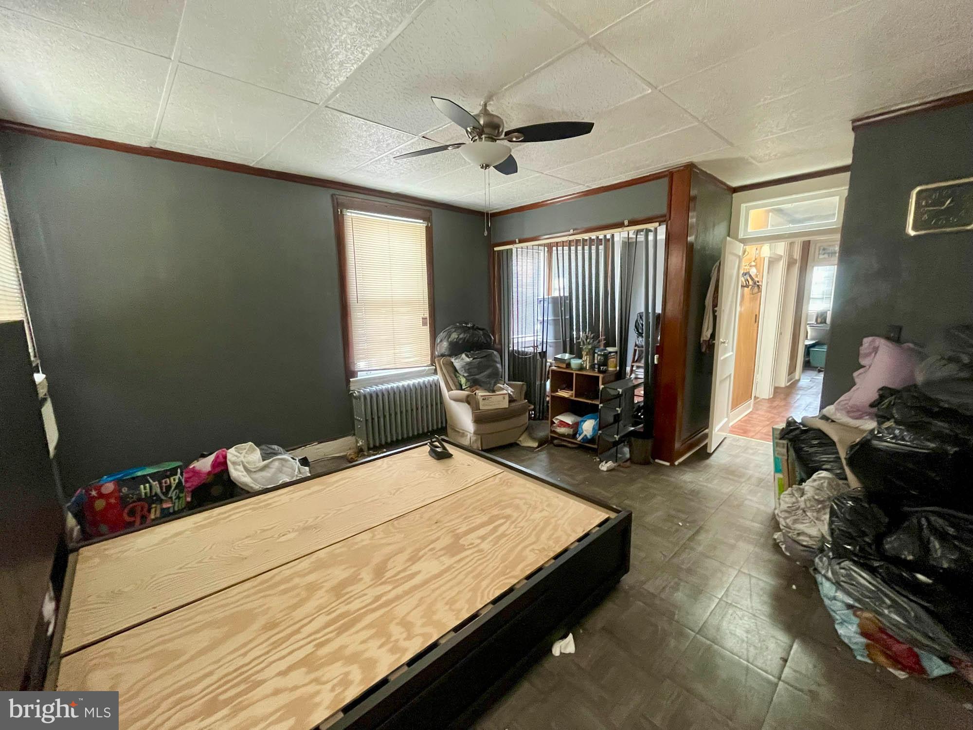 2701 Baker Street Baltimore, MD 21216 - Photo 7 of 16 a bed room with a bed mirror and a window