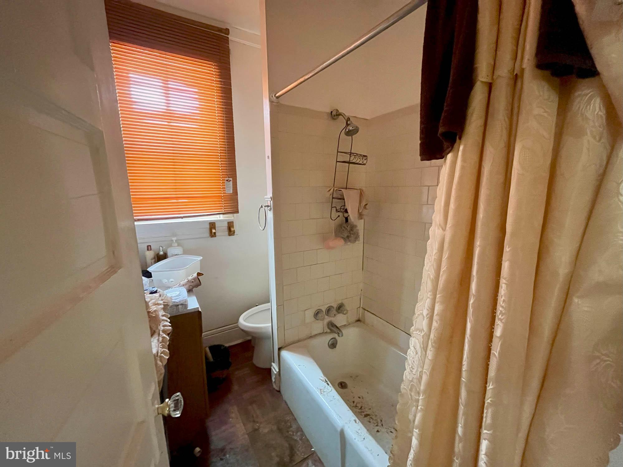 2701 Baker Street Baltimore, MD 21216 - Photo 9 of 16 a bath room with a toilet and a tub