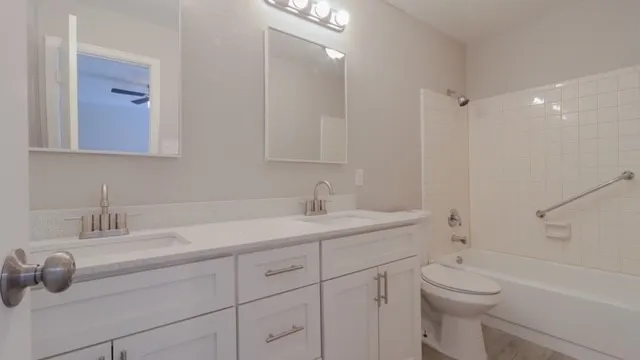 a bathroom with a sink toilet vanity and tub