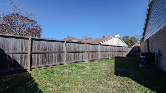 a view of backyard with wooden fence