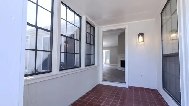 a view of a hallway with wooden floor and a living room
