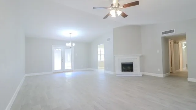 a view of an empty room with a fireplace and a window