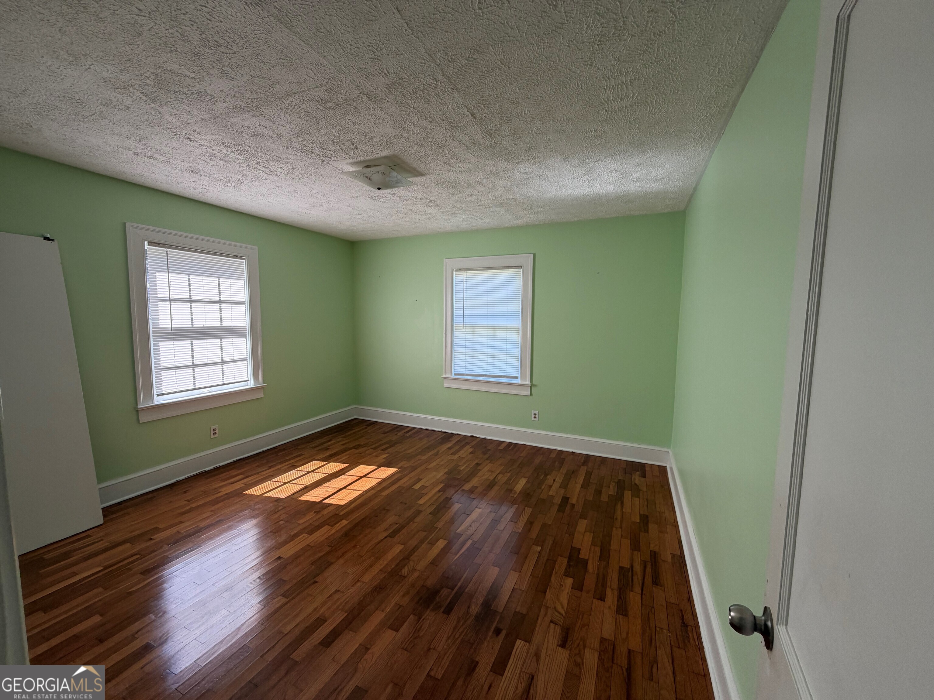2619 Maple Road Southeast Rome, GA 30161 - Photo 14 of 31 a view of an empty room with wooden floor and a window