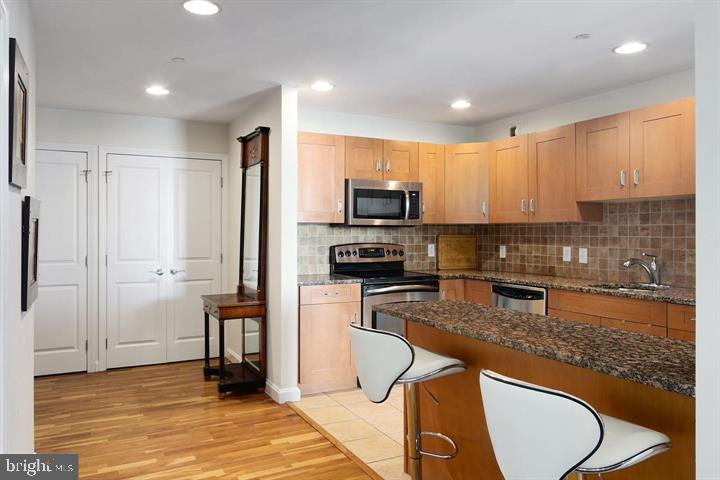 901 North Penn Street, Unit R1501 Philadelphia, PA 19123 - Photo 7 of 25 a kitchen with stainless steel appliances granite countertop a stove a sink a refrigerator a microwave and cabinets