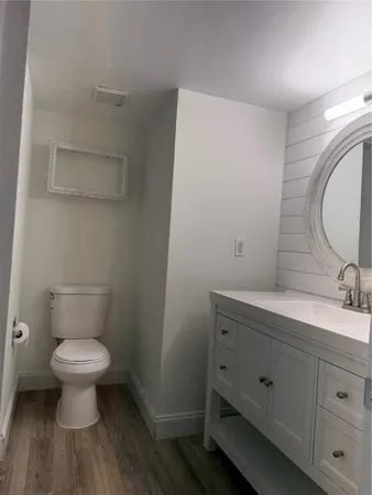 a bathroom with a toilet a sink and mirror