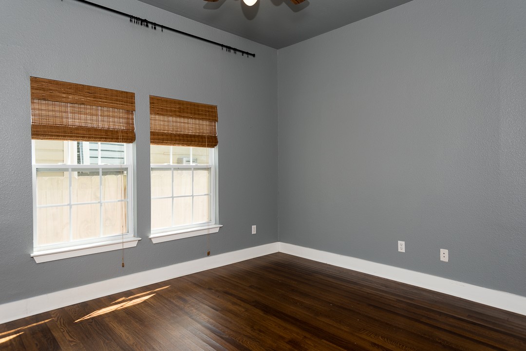 2805 Lafayette Avenue Austin, TX 78722 - Photo 4 of 23 Unfurnished room with baseboards, dark wood-style flooring, and a ceiling fan