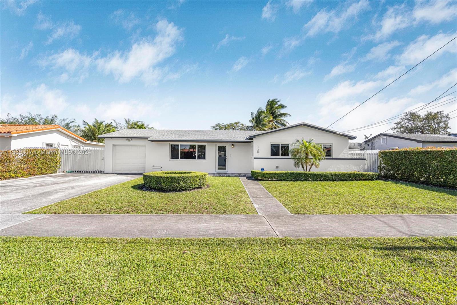 1301 Southwest 99th Court Miami, FL 33174 - Photo 1 of 35 a front view of a house with a yard and garage