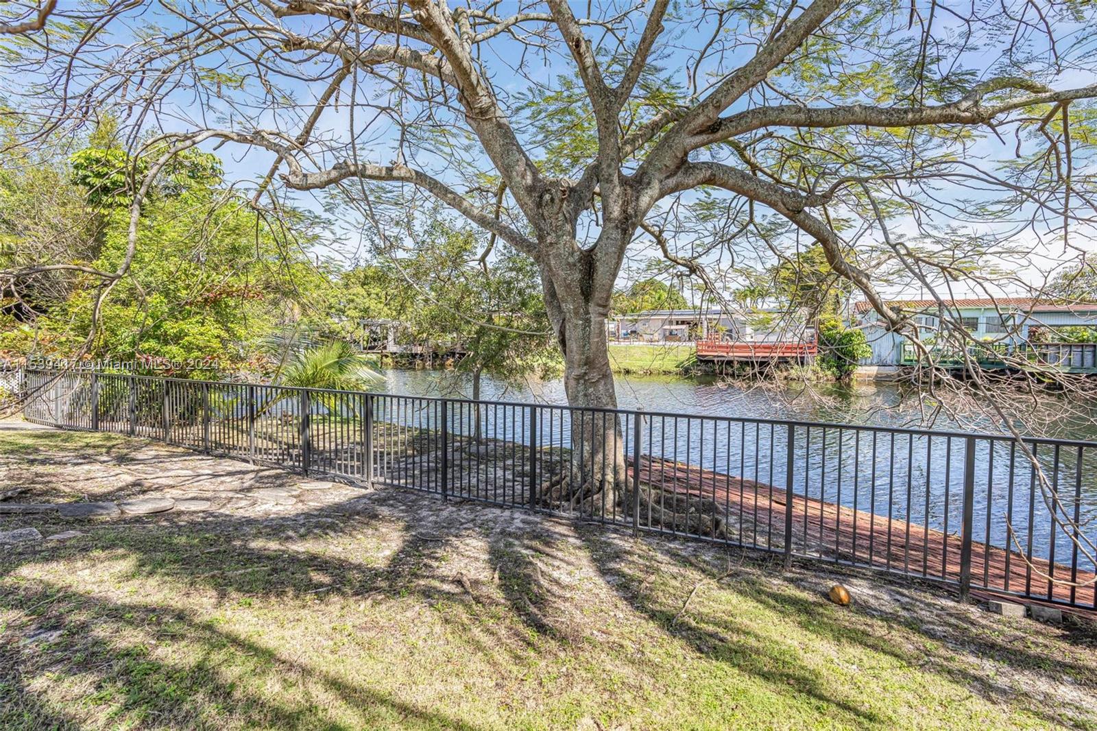 1301 Southwest 99th Court Miami, FL 33174 - Photo 27 of 35 a view of a yard with wooden fence and trees