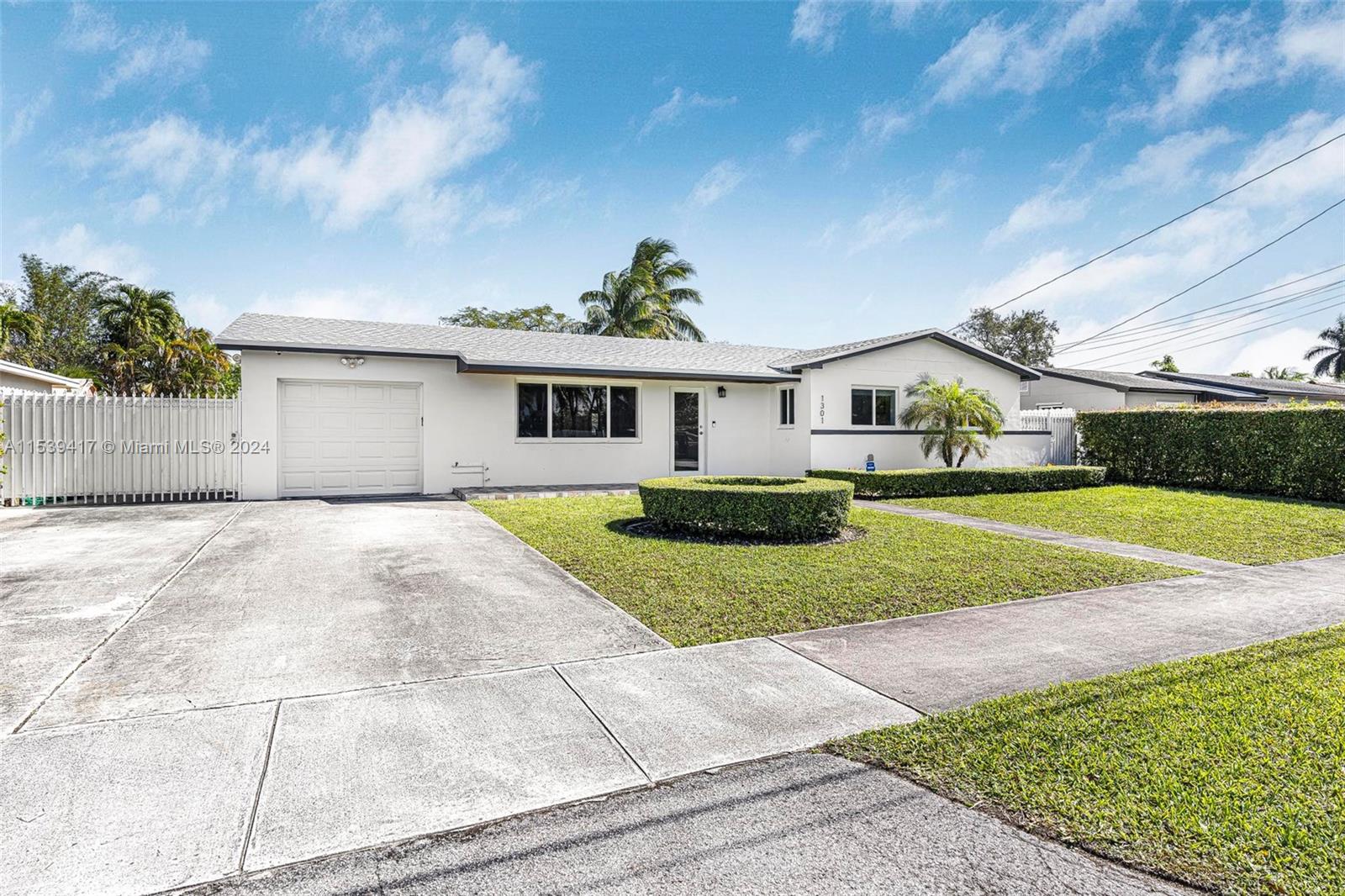 1301 Southwest 99th Court Miami, FL 33174 - Photo 3 of 35 a front view of a house with a yard and garage
