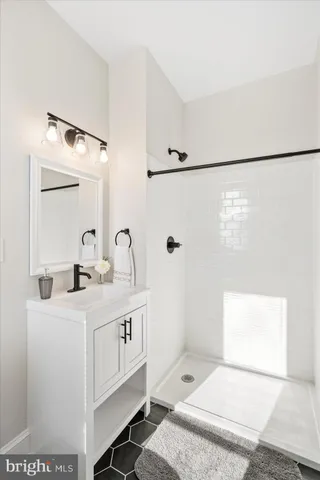 a bathroom with a sink a toilet a mirror and shower
