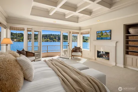 a spacious bedroom with a large bed and a fireplace with the outer view